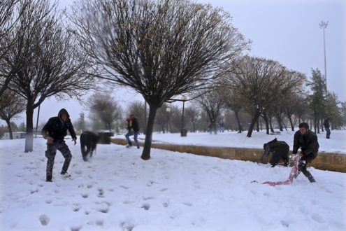 Jordanian people play with snow in Amman, Jordan, Thursday, Jan. 8, 2015. The wintry weather, which swooped across much of the Mideast on Tuesday, mostly silenced the guns in Syria and grounded government warplanes because of bad visibility. The Syrian war has so far killed more than 200,000 people and led to a massive humanitarian crisis, forcing more than 3 million to seek refuge abroad, mostly in Lebanon, Turkey, Jordan and Iraq. (AP Photo/Raad Adayleh)